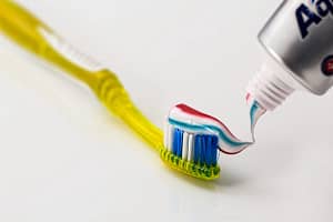 a yellow toothbrush and a colorful toothpaste